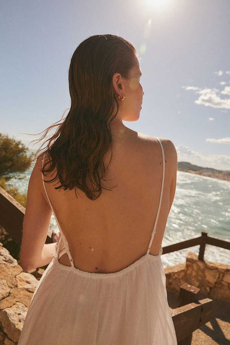 sandy beaches and ocean breezes, highlighting the dress's relaxed, effortless style.