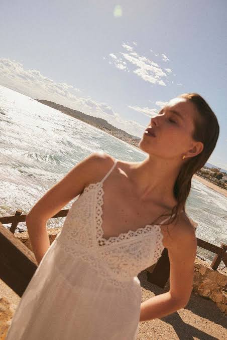 sandy beaches and ocean breezes, highlighting the dress's relaxed, effortless style.