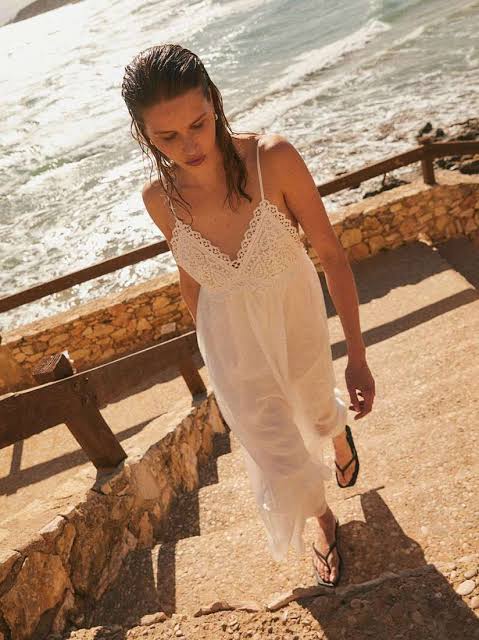sandy beaches and ocean breezes, highlighting the dress's relaxed, effortless style.